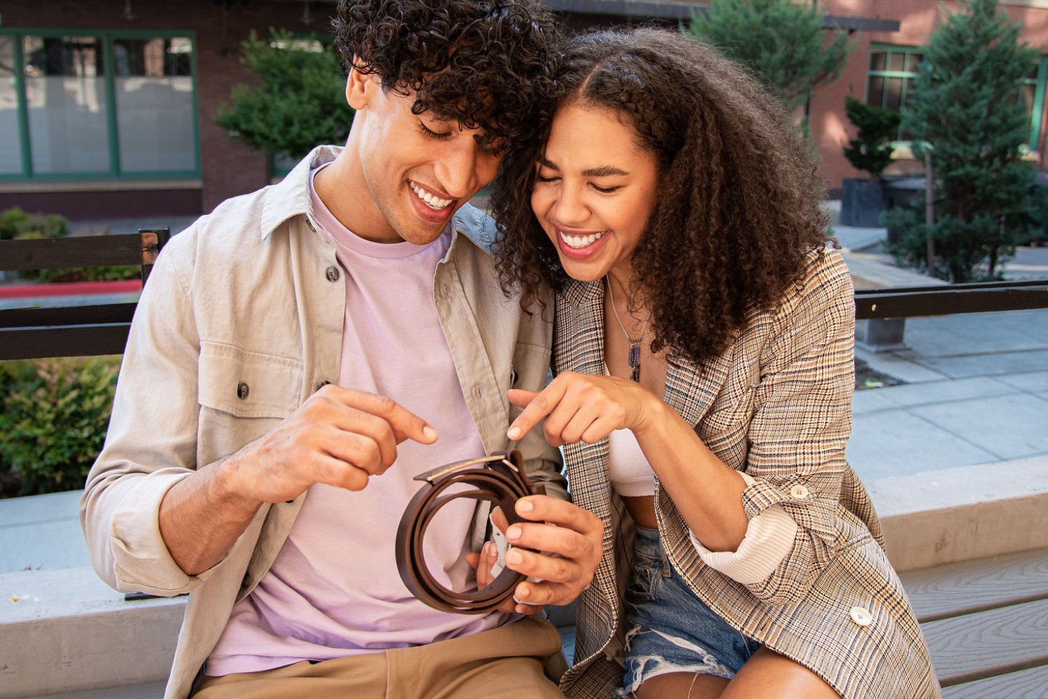 Couple opening a custom bronze anniversary belt buckle from Steel Toe Studios