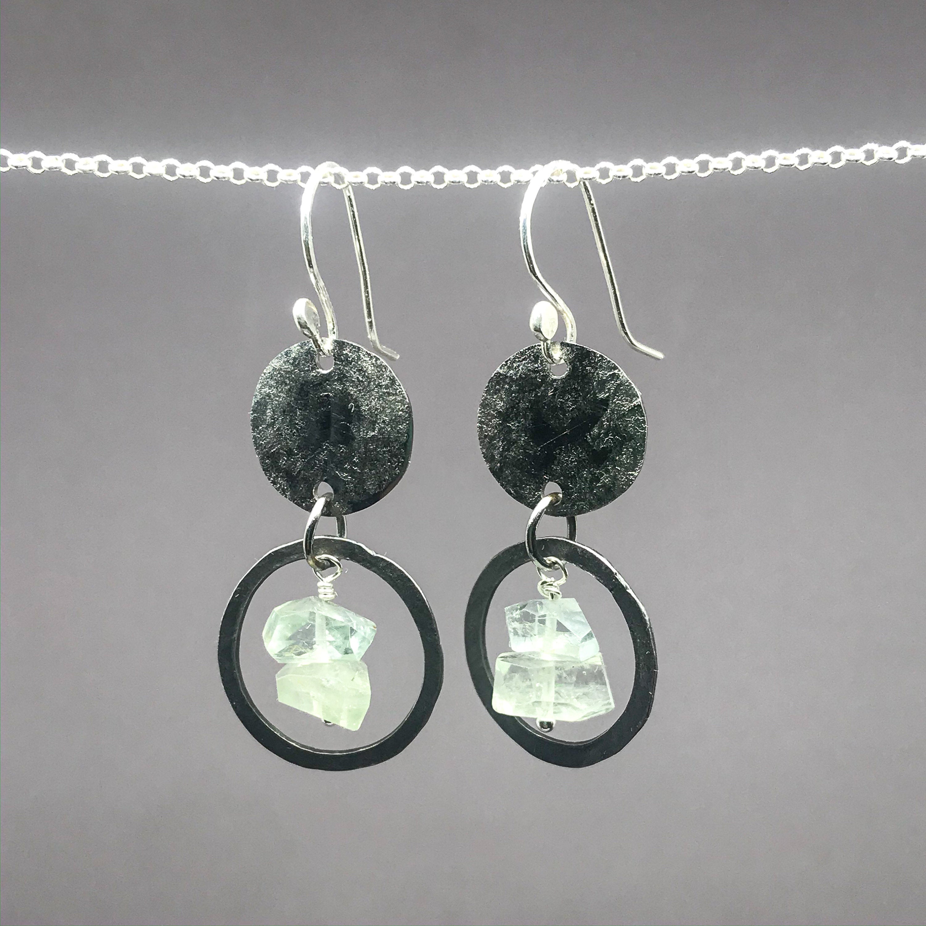 small stainless steel earrings with hammered small hoops around aquamraine nugget beads and suspended from hamered stainless steel discs on sterling silver ear hooks.
