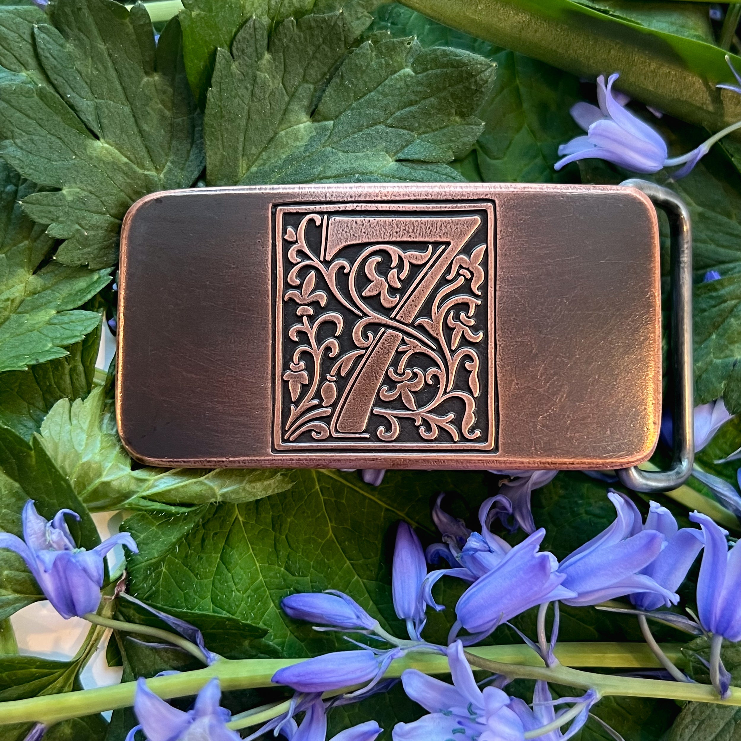 Copper belt buckle with ornate numeral 7 engraved