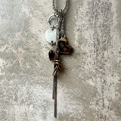Bronze heart with 8 tally engraving with other charms like bronze knot, stainless disc with garnet and snake chain tassel on a stainless chain.