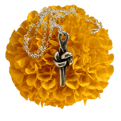 Pewter love knot pendant on a yellow marigold.